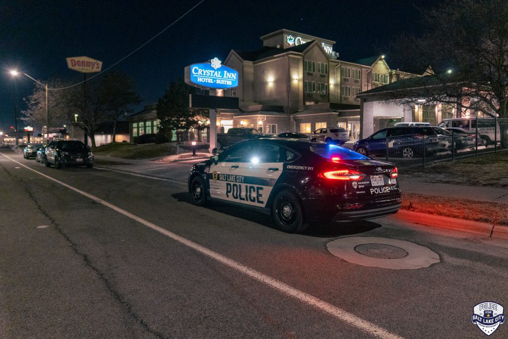 A police car with the lights on parked on the shoulder of the road