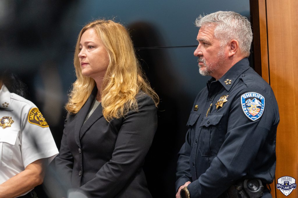 Two law enforcement officials standing together during a press conference.