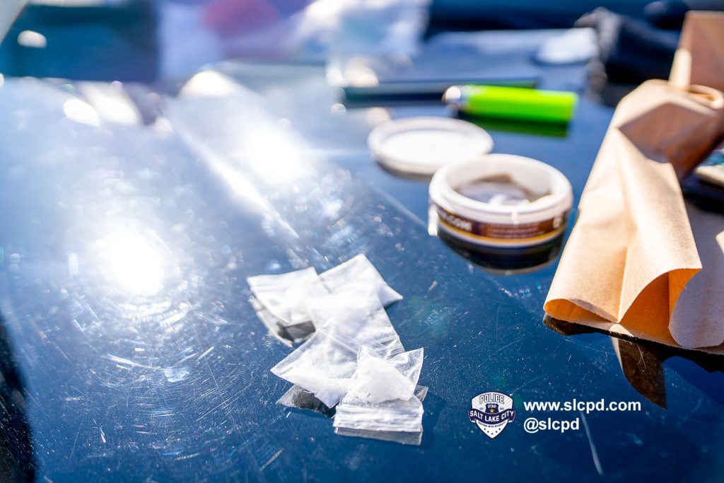 drugs in small bags on the hood of a police car