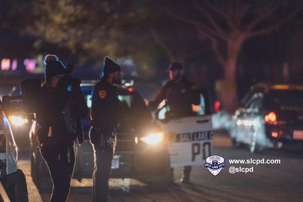 A photo of police officers and a crime lab technician at the scene of a shooting on Pacific Avenue in Salt Lake City.