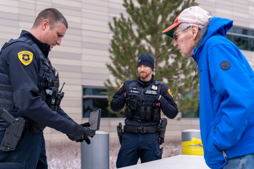 Two police officers and a community members at a gun buy-back event held at the Public Safety Building.