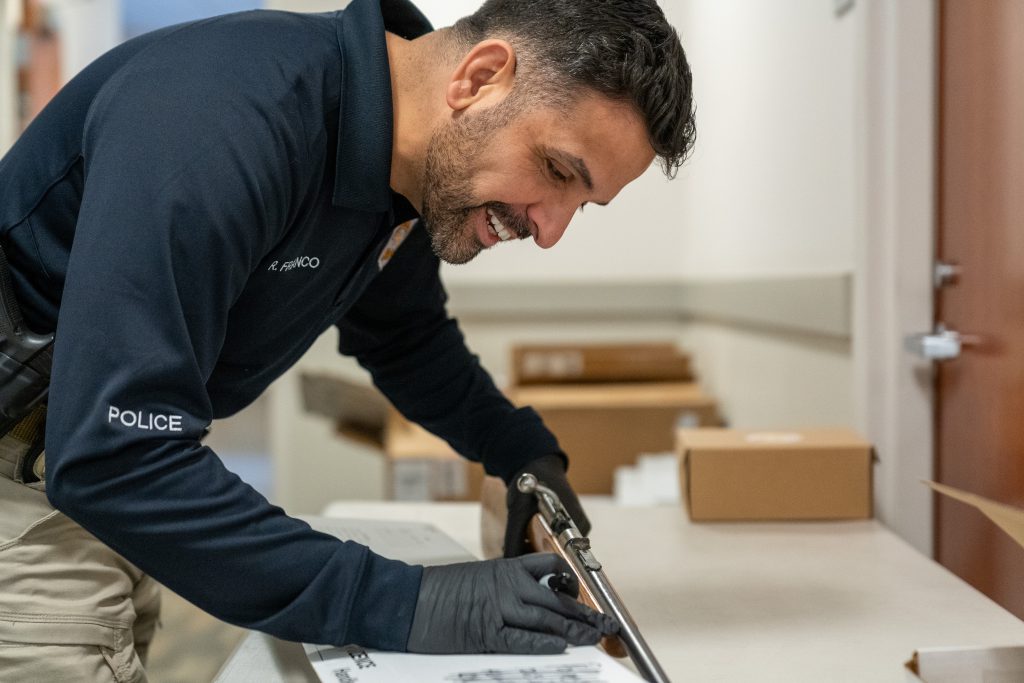 A detective inventorying a gun turned in by a community member.