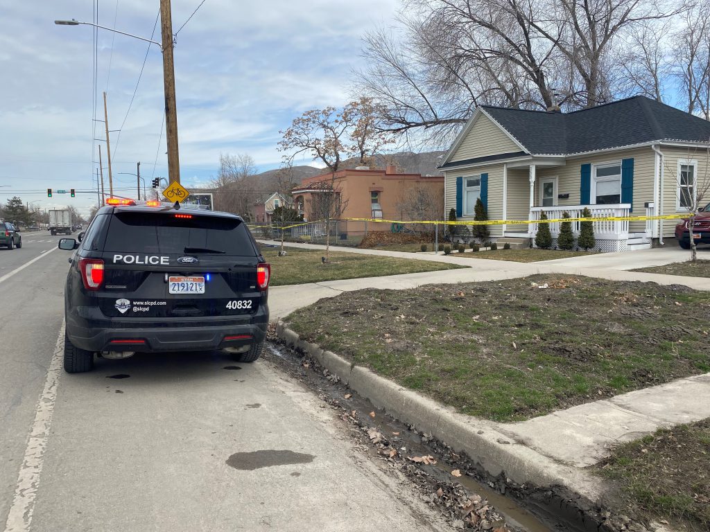 Photo of a police car and police do not cross tape.