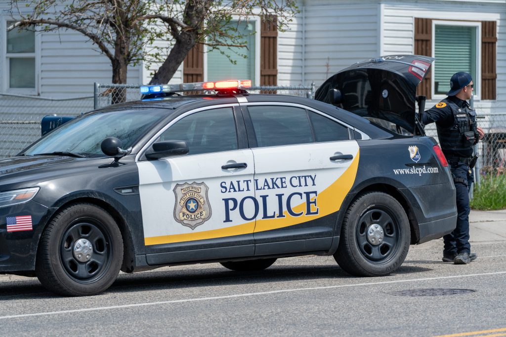 A police car with an officer standing nearby