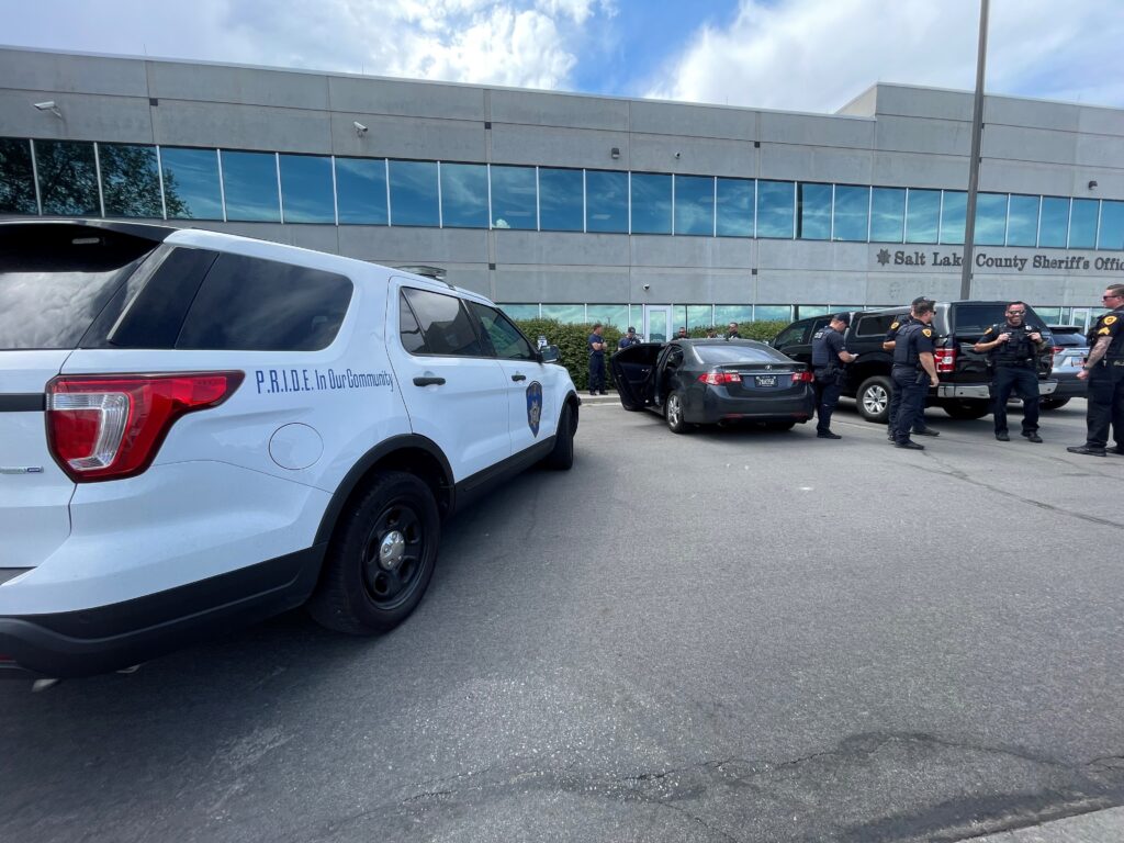 Photo: Salt Lake City Police officers stand next to a stolen car parked in front of the Salt Lake County Sheriff’s Office on Monday, August 5, 2024 (SLCPD photo – August 5, 2024).