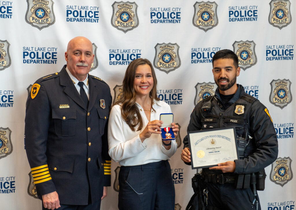 Mayor Erin Mendenhall and Chief Mike Brown award Officer Gabriel Paulino the Lifesaving Award